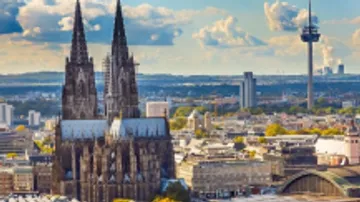 Gotische Kathedrale ragt über Stadtlandschaft.