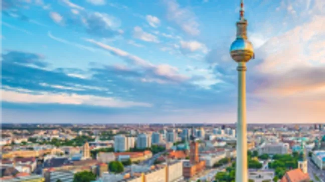 Berliner Fernsehturm über Skyline, blauer Himmel.