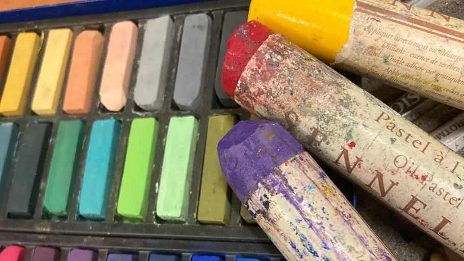 Bunte Pastellkreiden in einer Schachtel angeordnet.