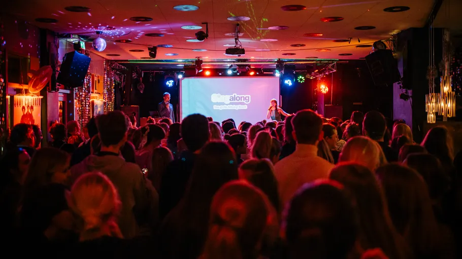 Crowded audience watching a stage performance.