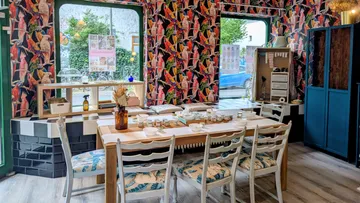 Colorful cafe interior with bird wallpaper.