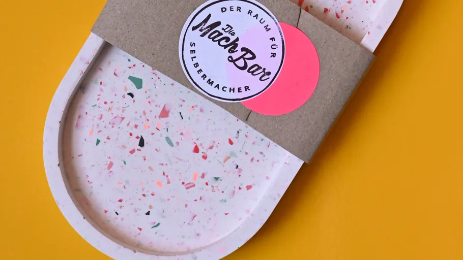 Colorful speckled tray with label on yellow background.