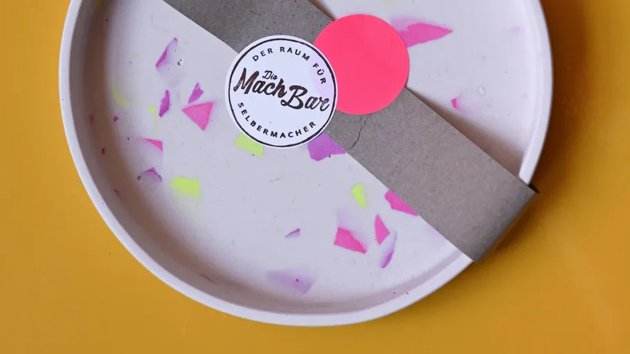 Decorative plate with colorful fragments and label.