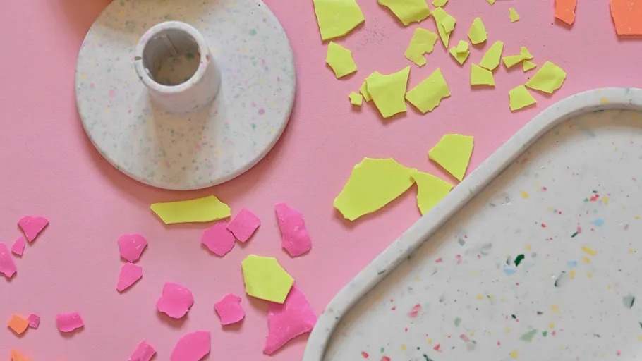 Colorful terrazzo plates on pink surface.