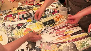 Hands creating collage with magazine cutouts.