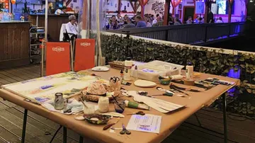 Basteltisch mit Kunstmaterialien im Freien.