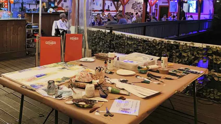 Craft table with art supplies at outdoor venue.