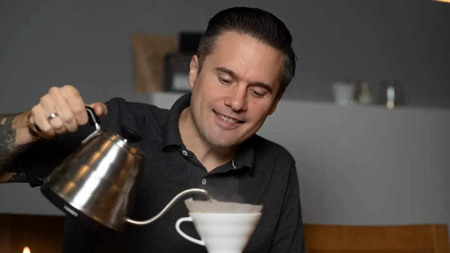 Person gießt heißes Wasser in Kaffeefilter.