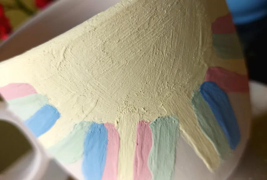 Painted ceramic pot with pastel stripes.