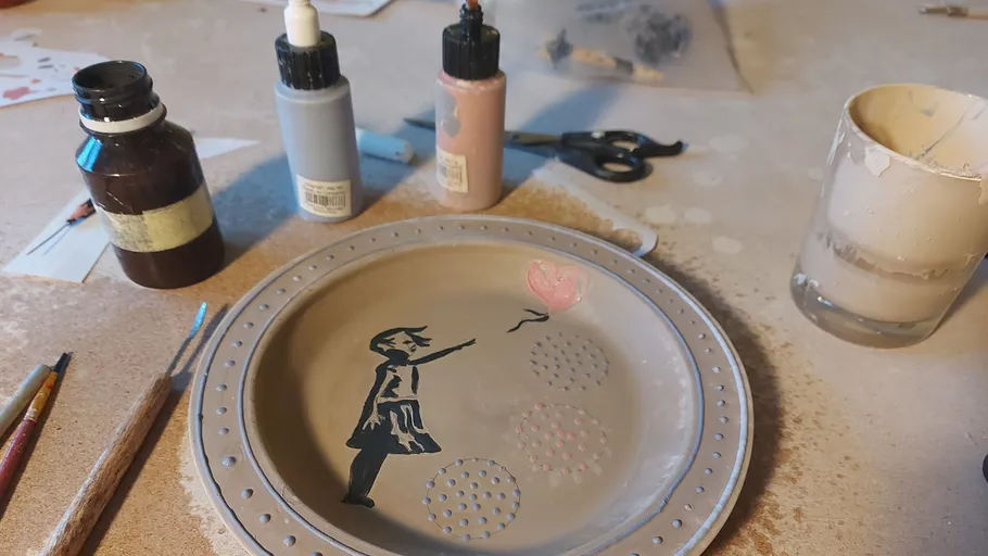Painted plate with girl and balloon design.