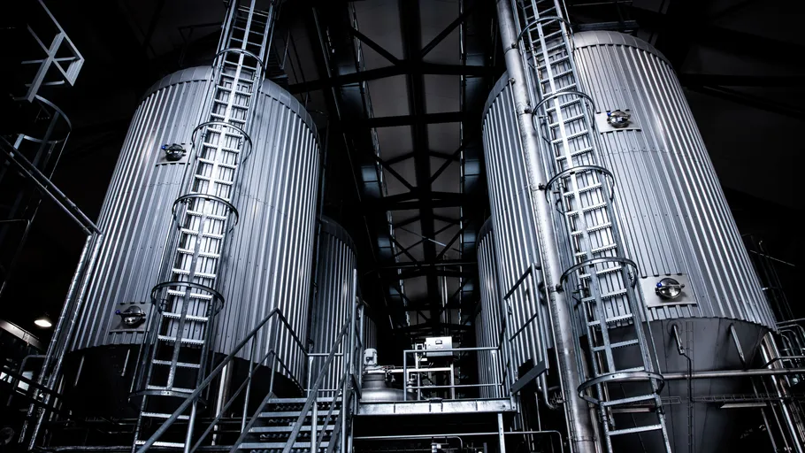 Large silver tanks inside an industrial facility.