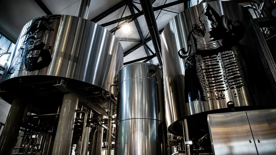 Metallic brewing tanks inside a brewery.
