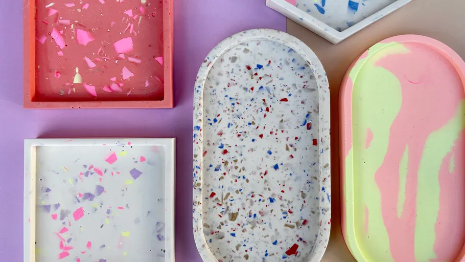 Bunte Terrazzo-Tabletts auf lila Hintergrund.
