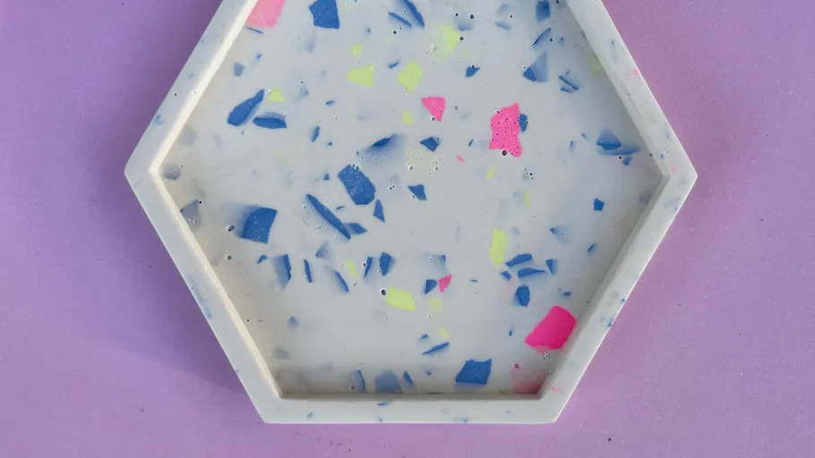 Hexagonal tray with colorful flecks on purple background.