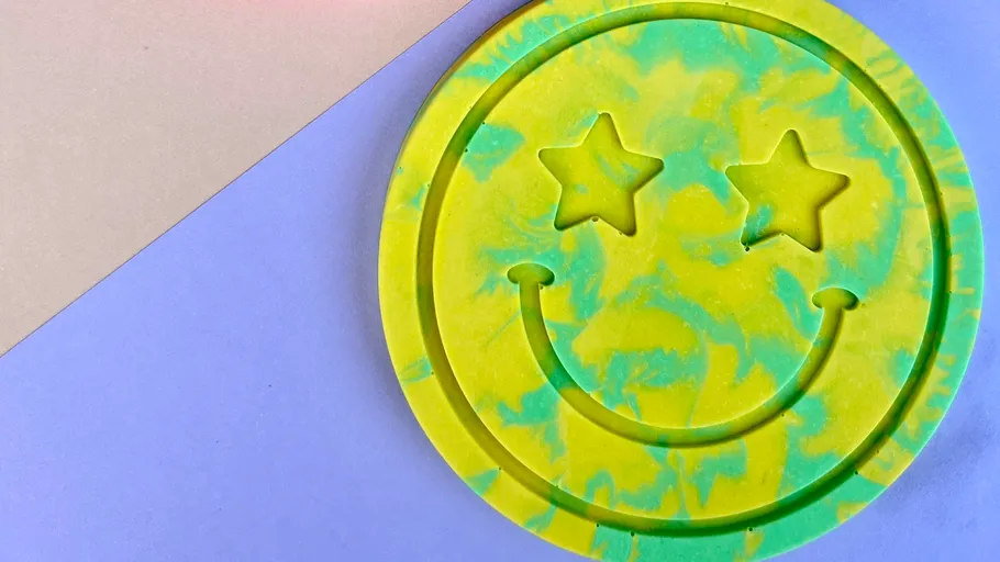 Yellow smiley face with star eyes on purple background.