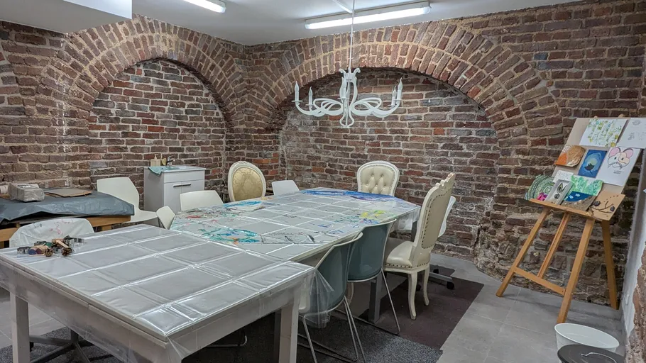 Kunststudio mit Backsteinwänden und Tischen.