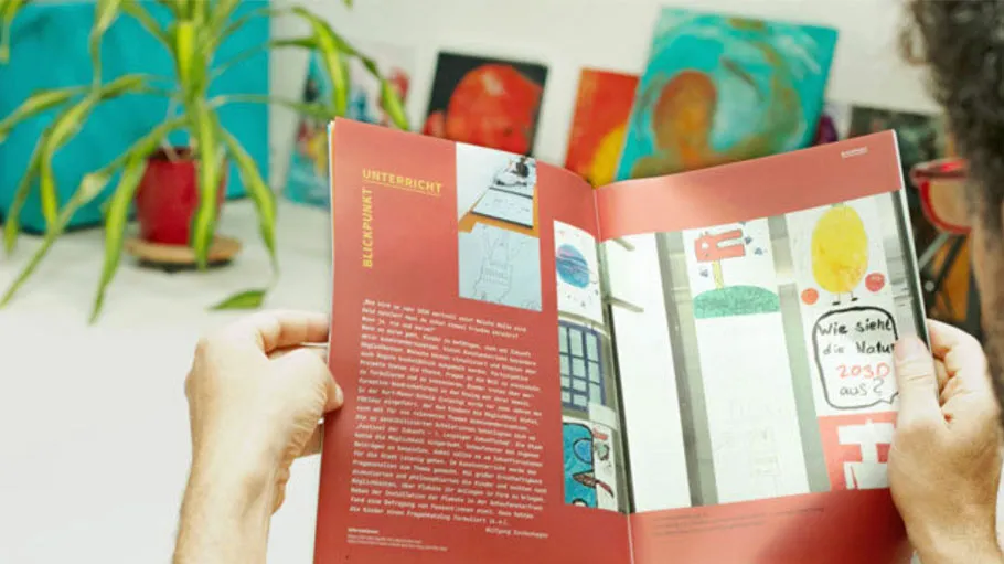 Person liest Magazin in kunstvollem Raum.