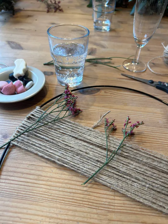 Craft materials and drink on wooden table.