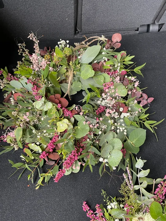 Blumenkranz auf dunkler Oberfläche liegend.