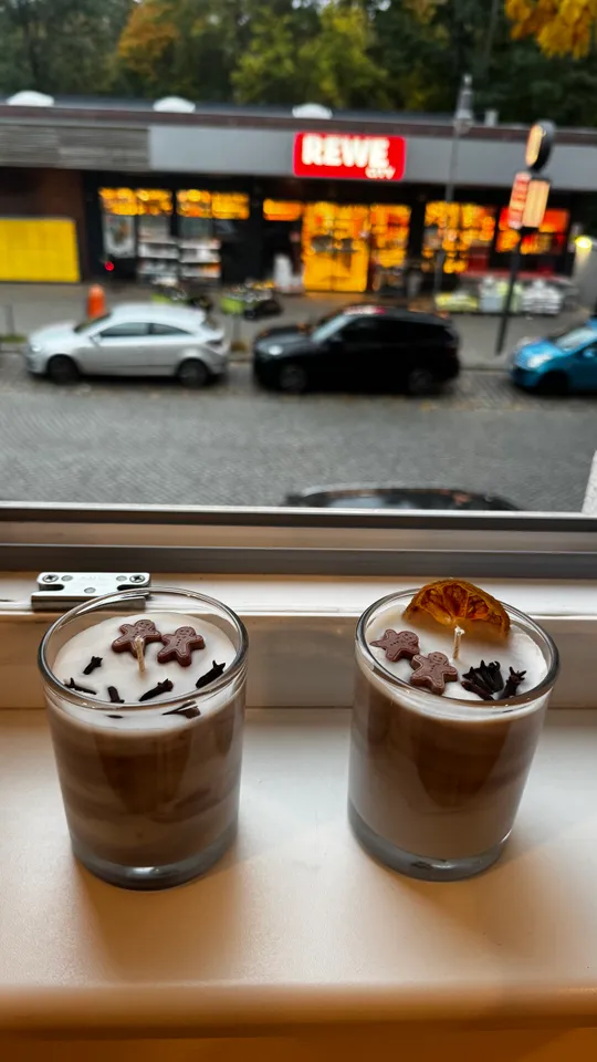 Zwei dekorierte Kerzen auf Fensterbrett, Straßenansicht.