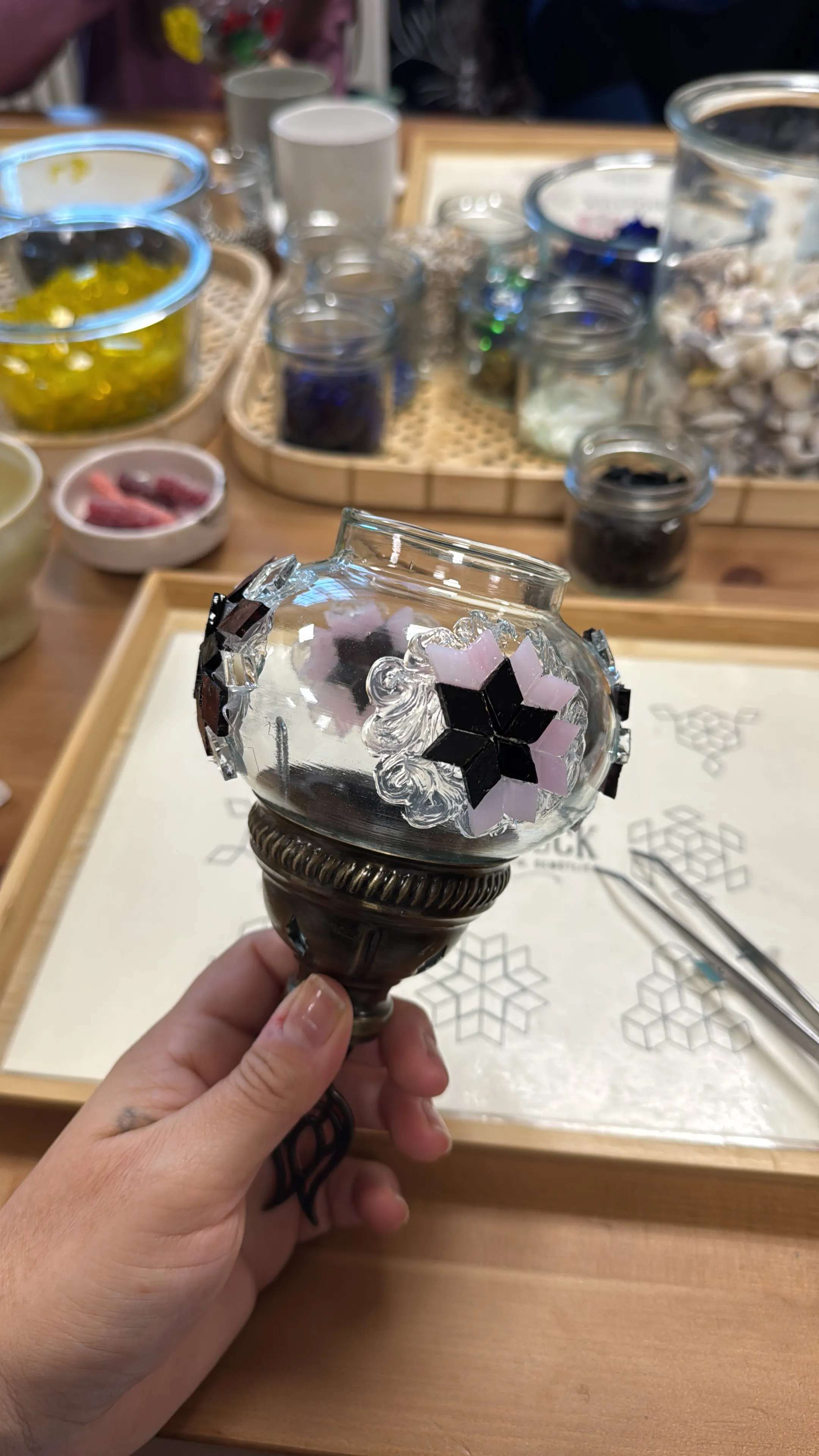 Hand hält verzierten Glaskugel in Werkstatt.