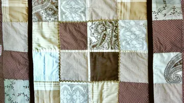 Patchworkdecke mit verschiedenen braunen Mustern.