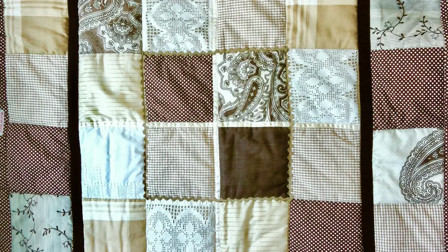 Patchworkdecke mit verschiedenen braunen Mustern.