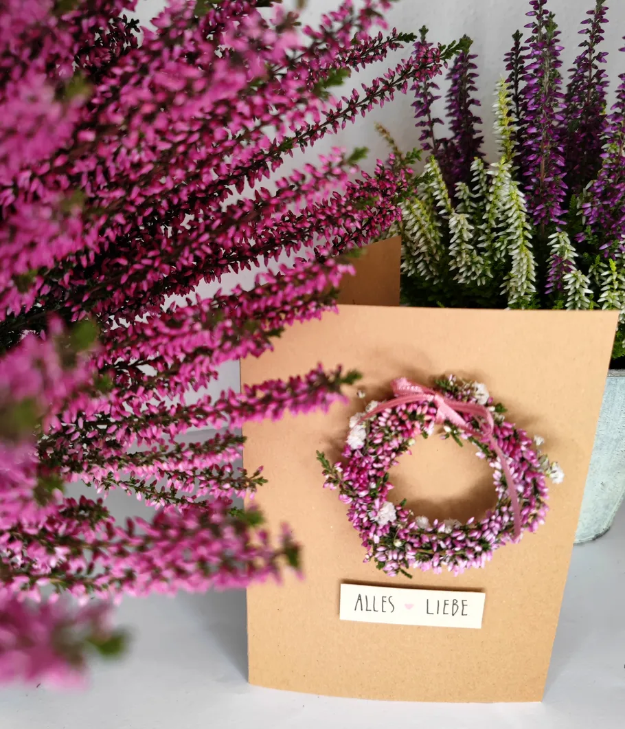 Pinke Blumen mit Karte 'Alles Liebe'.