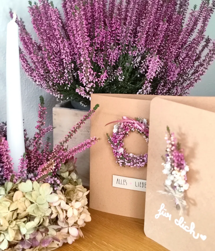 Karten mit Blumen, Kerze und Pflanzen präsentiert.