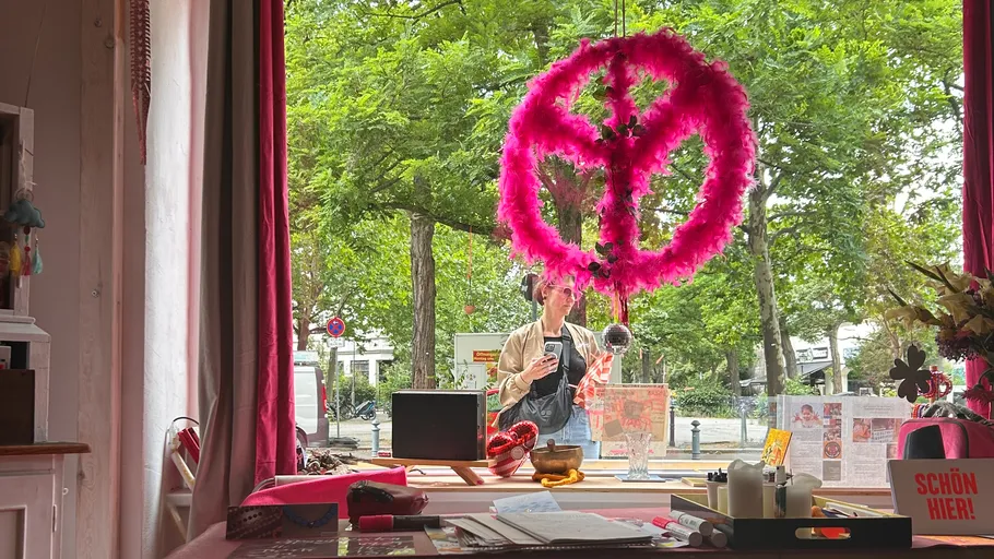 Woman looking through window with pink peace sign.