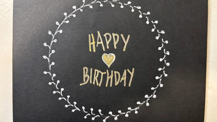 Karte mit 'Happy Birthday' von Kranz umgeben.