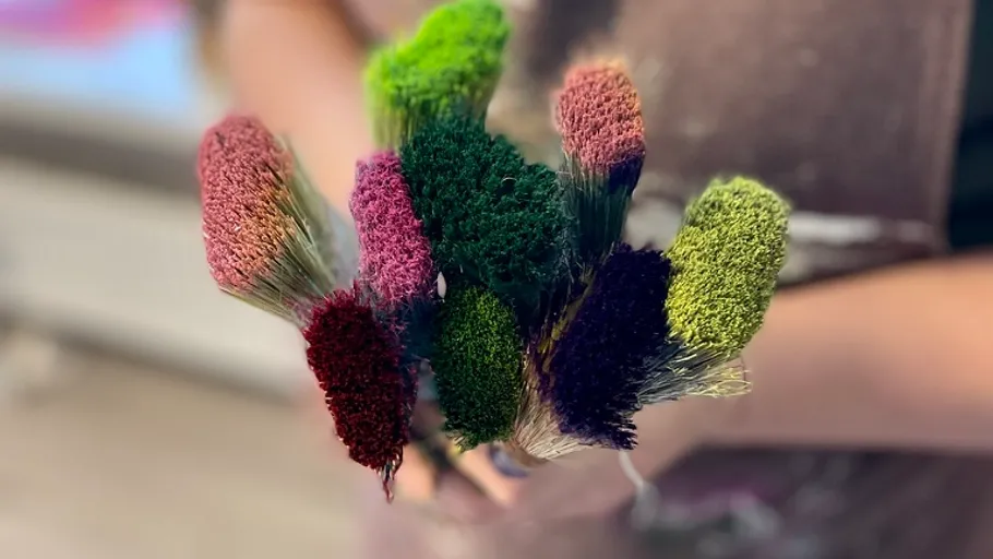 Colorful dried flowers held by a person.