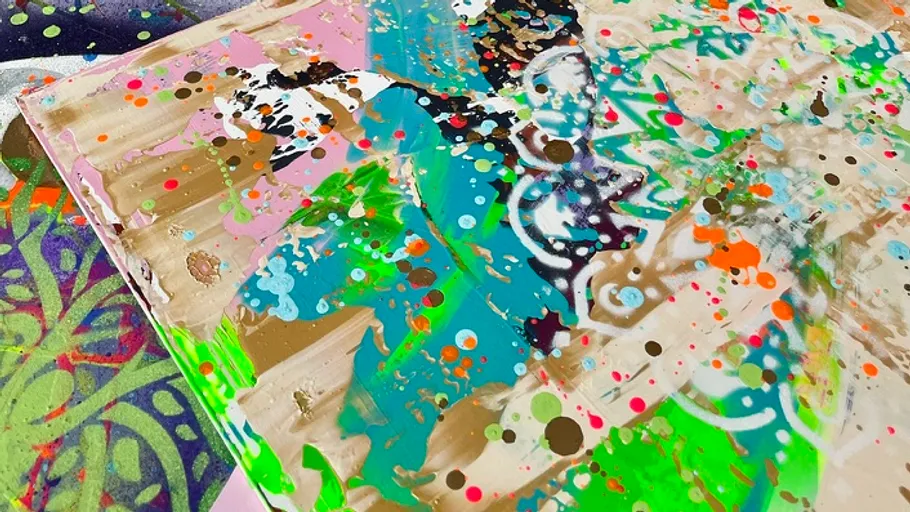 Colorful abstract painting with splatters and patterns.