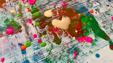 Colorful paint splatters on canvas background.