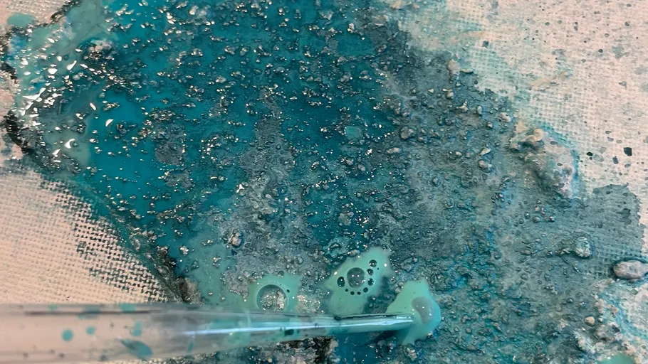 Blue liquid on textured surface with pipette.