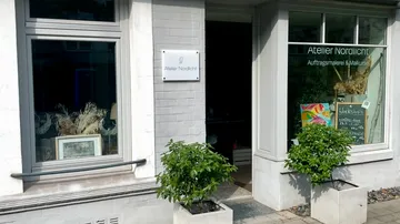 Art studio entrance with plants and windows.