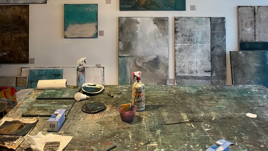 Art studio with abstract paintings on walls.