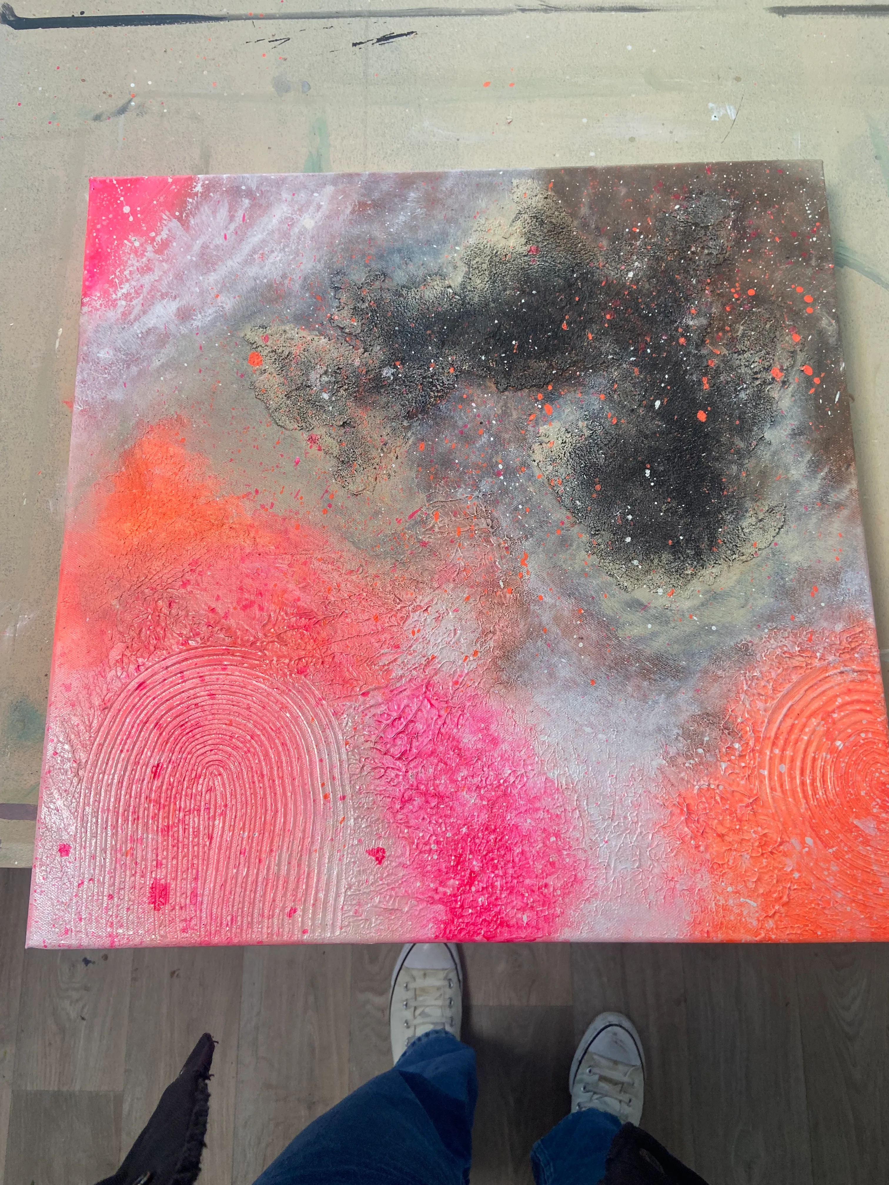 Abstract painting with vibrant colors on floor.