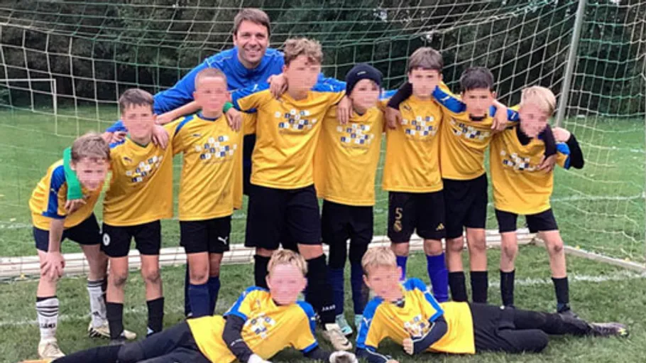 Jugendfußballteam posiert vor dem Tor.