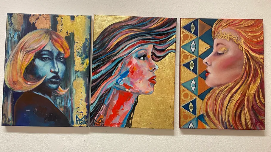 Three colorful portraits on white wall.