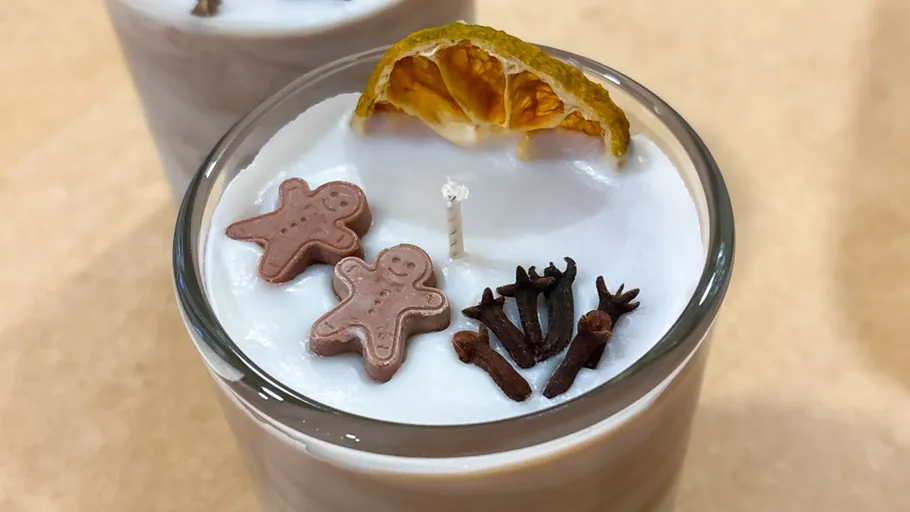 Dekorierte Kerze mit Orange, Lebkuchen und Nelken.