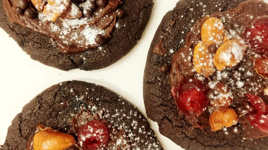 Drei Schokoladenkekse mit Früchten und Zucker.