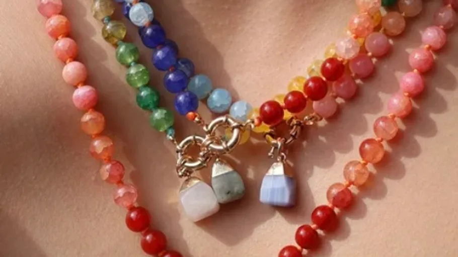 Colorful beaded necklaces with gemstone pendants.