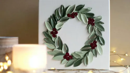 Leaf and berry wreath on canvas with candles.