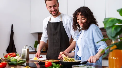 Couple cooking together in a kitchen.
