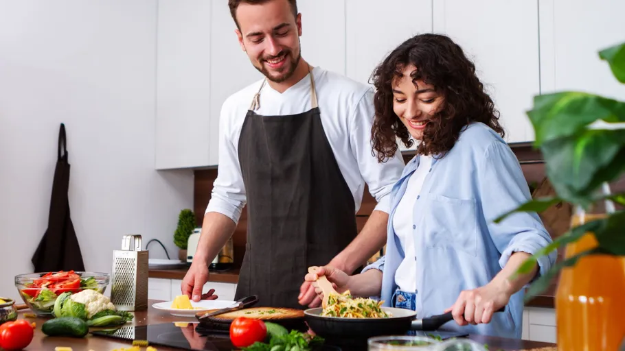 Couple cooking together in a kitchen.