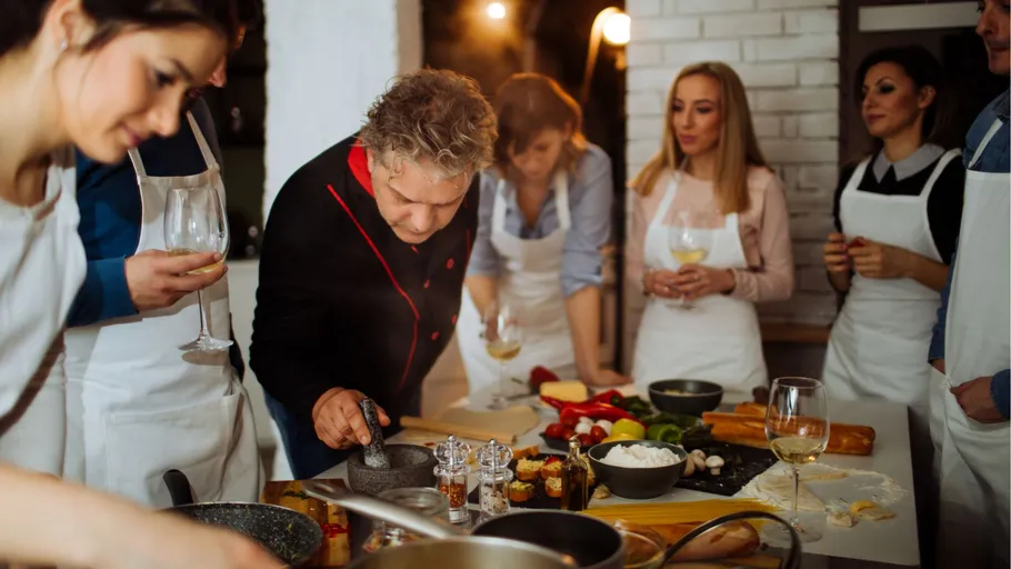 Group cooking class with participants around a table.