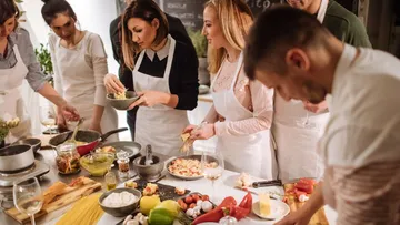 Menschen kochen gemeinsam in einer Küche.