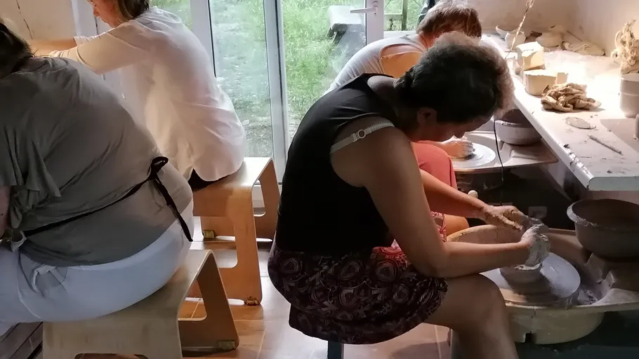 People making pottery in a workshop.