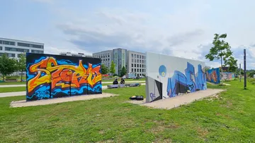 Mit Graffiti bedeckte Wände im grünen Stadtpark.